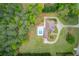 Aerial view of home with circular driveway, pool, patio, and beautiful landscaping surrounded by forest at 5040 Fawn Valley Dr, Loganville, GA 30052