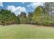 Spacious backyard with a lush green lawn, mature trees, and a serene natural setting at 5040 Fawn Valley Dr, Loganville, GA 30052