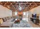 Basement entertainment area featuring an exposed ceiling, a sectional sofa, and a TV at 5040 Fawn Valley Dr, Loganville, GA 30052