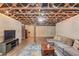 Basement living space with exposed ceiling, with a brick fireplace in the distance at 5040 Fawn Valley Dr, Loganville, GA 30052