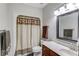 Traditional bathroom with a dark wood vanity, patterned shower curtain, and coordinating towel accents at 5040 Fawn Valley Dr, Loganville, GA 30052