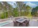 Spacious outdoor deck featuring a dining table with six chairs, white railings, and views of the landscaped yard and pool at 5040 Fawn Valley Dr, Loganville, GA 30052