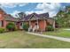 Home exterior featuring brick and siding, a well-kept lawn, and stepping stones to a welcoming side entrance at 5040 Fawn Valley Dr, Loganville, GA 30052