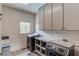 Laundry room with modern washer, dryer, and built-in storage cabinets at 5040 Fawn Valley Dr, Loganville, GA 30052