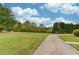 Expansive front yard featuring a long driveway, well-maintained lawn, and lush landscaping at 5040 Fawn Valley Dr, Loganville, GA 30052