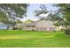 Large backyard view featuring lush greenery, a covered patio, and a well-maintained lawn at 130 Mimosa Dr, Fayetteville, GA 30214