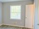 Bright bedroom with large window overlooking yard and door leading to another room at 130 Mimosa Dr, Fayetteville, GA 30214