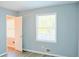 Bright bedroom featuring light blue walls, wood-look floors, and a view to the outdoors at 130 Mimosa Dr, Fayetteville, GA 30214