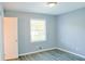 This cozy bedroom is highlighted with light blue walls, wood-look floors, and a bright window at 130 Mimosa Dr, Fayetteville, GA 30214