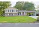 Charming home boasts a large front lawn and a convenient carport, blending classic design with practical features at 130 Mimosa Dr, Fayetteville, GA 30214