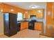 Functional kitchen featuring wooden cabinets, black appliances, and a light-colored tile floor at 130 Mimosa Dr, Fayetteville, GA 30214