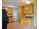 Functional kitchen with wooden cabinetry, black appliances, tiled flooring, and bright overhead lighting at 130 Mimosa Dr, Fayetteville, GA 30214