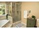 Bathroom featuring a glass door shower, tub, and neutral color palette at 1473 Wildwood Way, Hampton, GA 30228