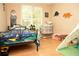 Bedroom with hardwood floors, dinosaur decorations, and a window at 1473 Wildwood Way, Hampton, GA 30228