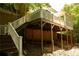 A shot from below shows the home's sunroom and raised deck with a white railing at 1473 Wildwood Way, Hampton, GA 30228