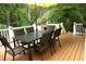 A six-chair dining set sits beneath an umbrella on this home's wooden deck at 1473 Wildwood Way, Hampton, GA 30228