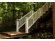 Deck stairs with white railings descend into the surrounding forest at 1473 Wildwood Way, Hampton, GA 30228