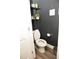 Contemporary half bathroom with modern fixtures, dark wall paint, and chic shelving, perfect for guests at 1473 Wildwood Way, Hampton, GA 30228