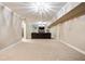 Spacious basement area is carpeted and has a large seating area with modern lighting at 35 Inverleigh Row, Covington, GA 30014