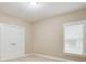 Bedroom featuring neutral carpet, standard window, and double doors to the closet at 35 Inverleigh Row, Covington, GA 30014