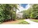 View of exterior with mature trees, landscaped yard and circular driveway leading to a brick home at 35 Inverleigh Row, Covington, GA 30014