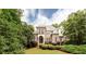 Exterior view of brick house with landscaped yard, trees and manicured bushes at 35 Inverleigh Row, Covington, GA 30014