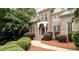 Brick home featuring an arched front door, a small balcony, and well-maintained landscaping at 35 Inverleigh Row, Covington, GA 30014