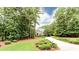 View of exterior with mature trees, landscaped yard and circular driveway leading to a brick home at 35 Inverleigh Row, Covington, GA 30014