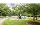 Community playground featuring a slide and swing set surrounded by lush trees and green grass, close to the tennis courts at 35 Inverleigh Row, Covington, GA 30014