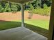 Relaxing covered back porch overlooking a landscaped backyard and wooded area, offering a tranquil outdoor space at 3032 Farm Tract Trl, Woodstock, GA 30189