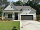 Charming single-story home with a two-car garage, covered porch, and professionally landscaped front yard at 3032 Farm Tract Trl, Woodstock, GA 30189