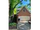 Brick exterior featuring a two-car garage and staircase with lush surrounding greenery at 782 Myrtle Ne St # B, Atlanta, GA 30308