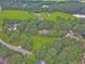 A home surrounded by lush greenery, with a glimpse of nearby ponds and other neighborhood homes from above at 2010 Bennett Rd, Grayson, GA 30017