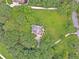 An aerial shot showing the house nestled among mature trees, surrounded by a lush green lawn at 2010 Bennett Rd, Grayson, GA 30017