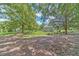 Spacious backyard with mature trees, lush lawn, and views of the home's exterior at 2010 Bennett Rd, Grayson, GA 30017