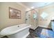 Bright bathroom with free standing tub and glass shower, complemented by neutral walls and tile floor at 2010 Bennett Rd, Grayson, GA 30017