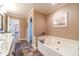 Bright bathroom featuring a soaking tub, granite countertops, and neutral walls at 2010 Bennett Rd, Grayson, GA 30017