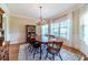 Elegant dining room featuring a large wooden table, chandelier, and large windows with sheer curtains at 2010 Bennett Rd, Grayson, GA 30017