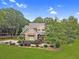Two-story home with stone and green siding, a covered porch, landscaping, and an American flag in the front yard at 2010 Bennett Rd, Grayson, GA 30017