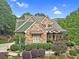 Charming two-story home with stone and green siding, complemented by landscaped gardens and an American flag at 2010 Bennett Rd, Grayson, GA 30017