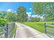 Long driveway leading to a beautiful home, surrounded by a lush green lawn and mature trees under a blue sky at 2010 Bennett Rd, Grayson, GA 30017