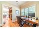 Inviting home office with wood desk, large window, and wood floors, offering a functional workspace at 2010 Bennett Rd, Grayson, GA 30017