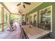 View of the outdoor dining on a covered porch with ceiling fans and wooden rocking chair at 2010 Bennett Rd, Grayson, GA 30017
