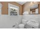 Bathroom featuring white tile, toilet, sink, and window at 3746 Gladney Dr, Atlanta, GA 30341