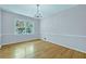 Cozy bedroom with hardwood floors, neutral wall paint, and a large window at 3746 Gladney Dr, Atlanta, GA 30341