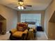Cozy bedroom featuring a ceiling fan, sitting area, and large window at 1604 Haven Cir, Douglasville, GA 30135