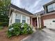 This home features a brick exterior, a red front door, and beautiful hydrangea bushes in the front yard at 1604 Haven Cir, Douglasville, GA 30135