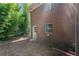 Exterior view of brick home and backyard access featuring a clean backdrop with lots of green trees at 3888 Lindley Cir, Powder Springs, GA 30127