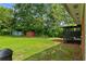 Spacious backyard with green lawn, storage sheds, and a covered deck, ideal for outdoor entertaining and storage solutions at 3888 Lindley Cir, Powder Springs, GA 30127