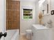 Cozy bathroom featuring a tiled shower, vanity, toilet, and window with natural light at 3888 Lindley Cir, Powder Springs, GA 30127